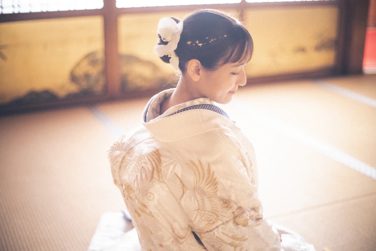 白い花を飾った洋髪を横から見せる白無垢姿の花嫁
