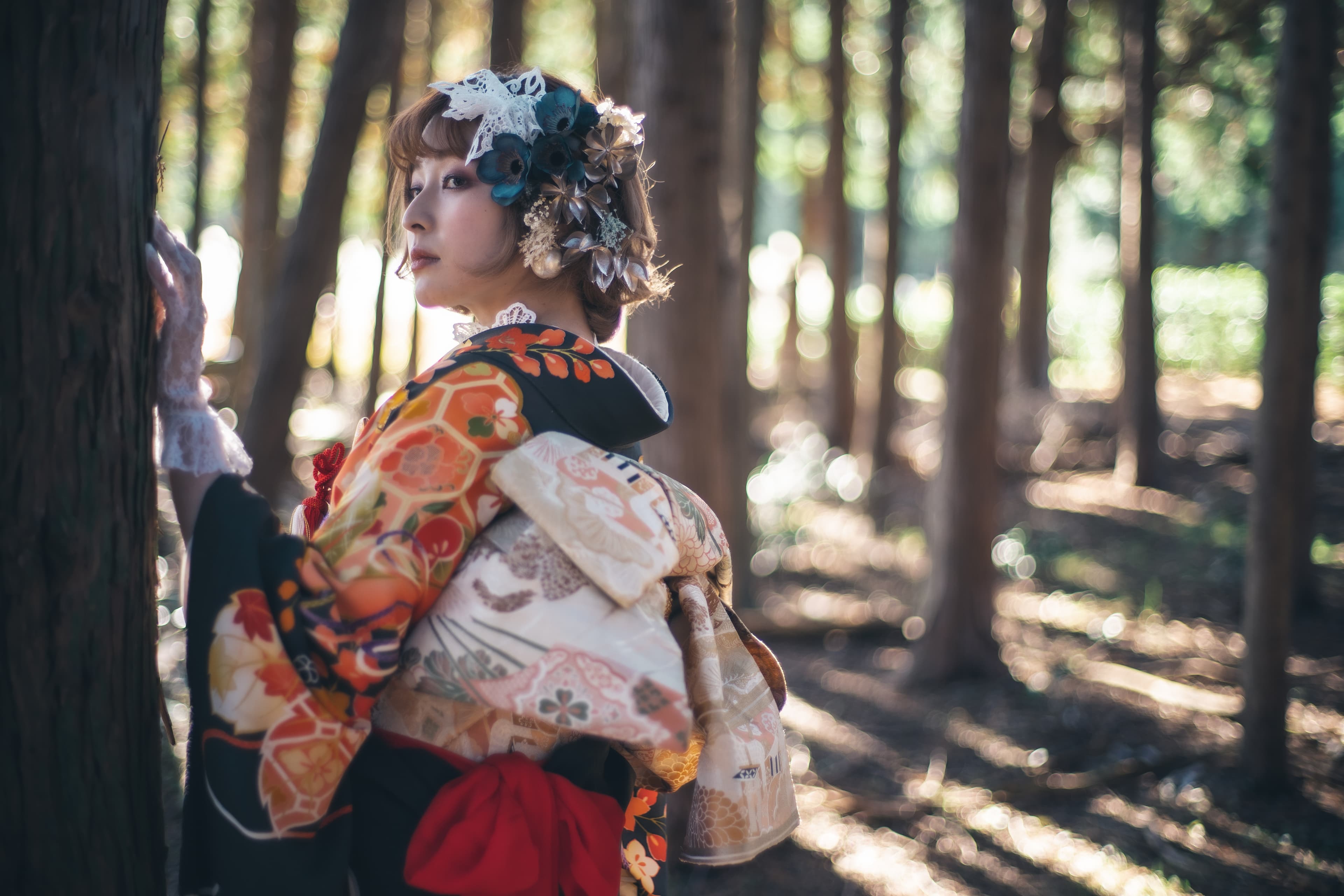 髪飾りをつけた洋髪と色打掛の花嫁が竹林で佇む姿
