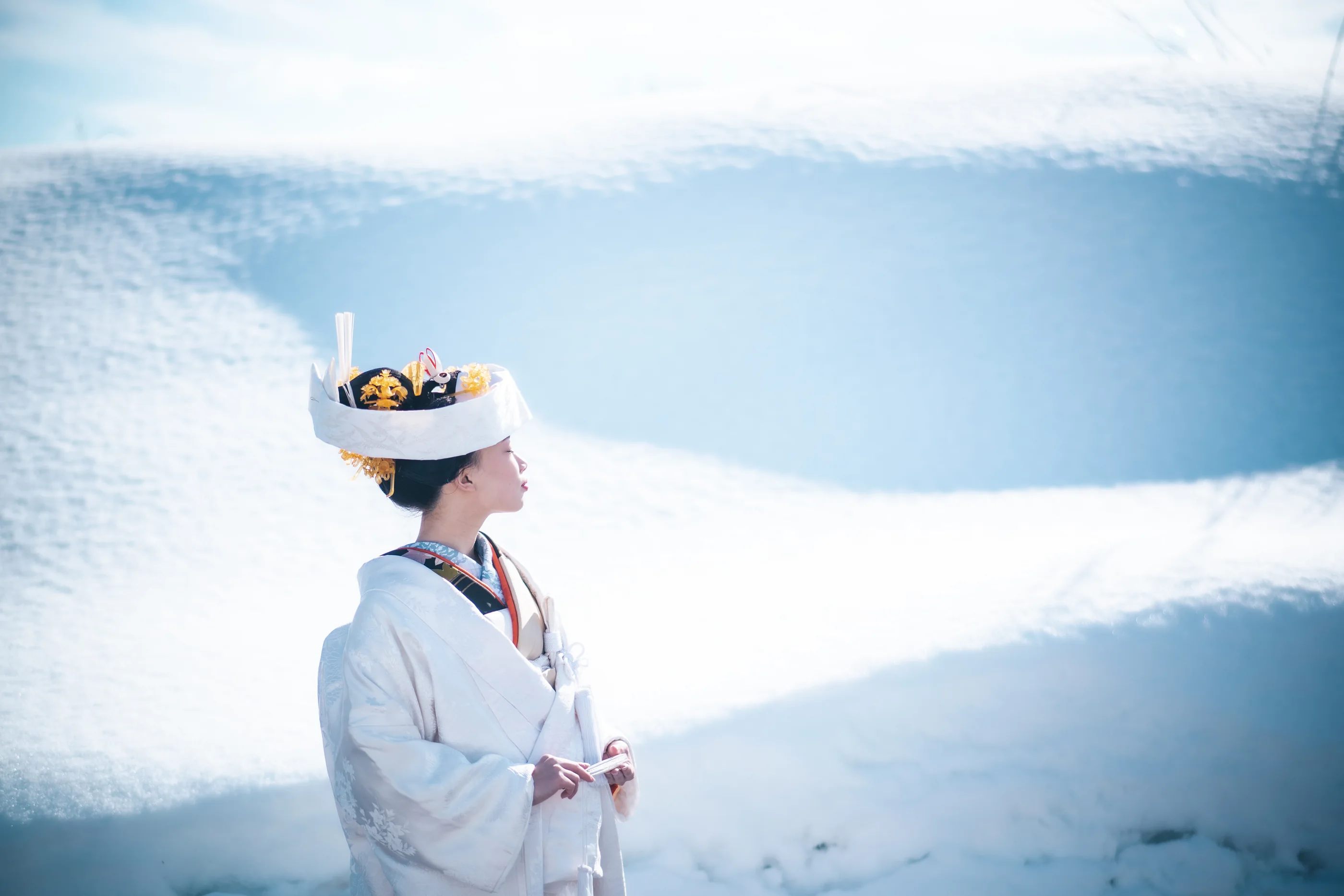 雪景色の中に立つ白無垢姿の花嫁