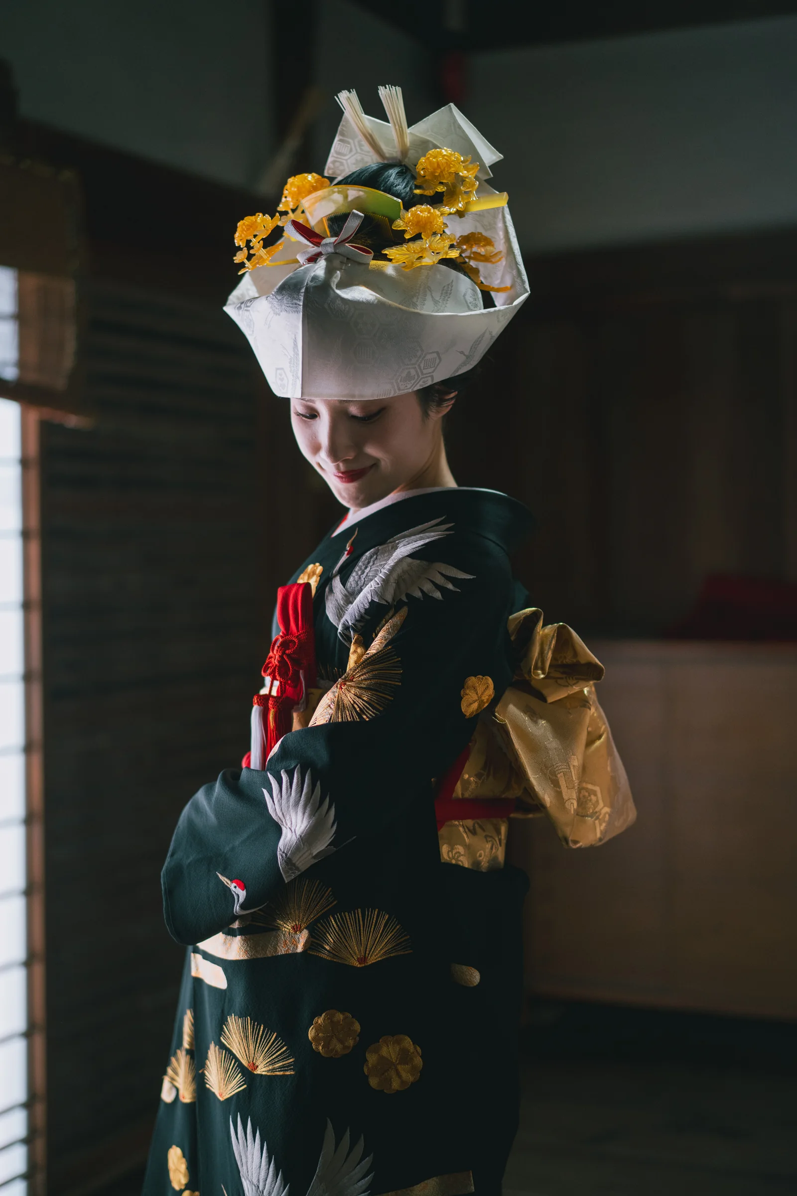 室内の柔らかな窓光を受ける黒引振袖姿の花嫁
