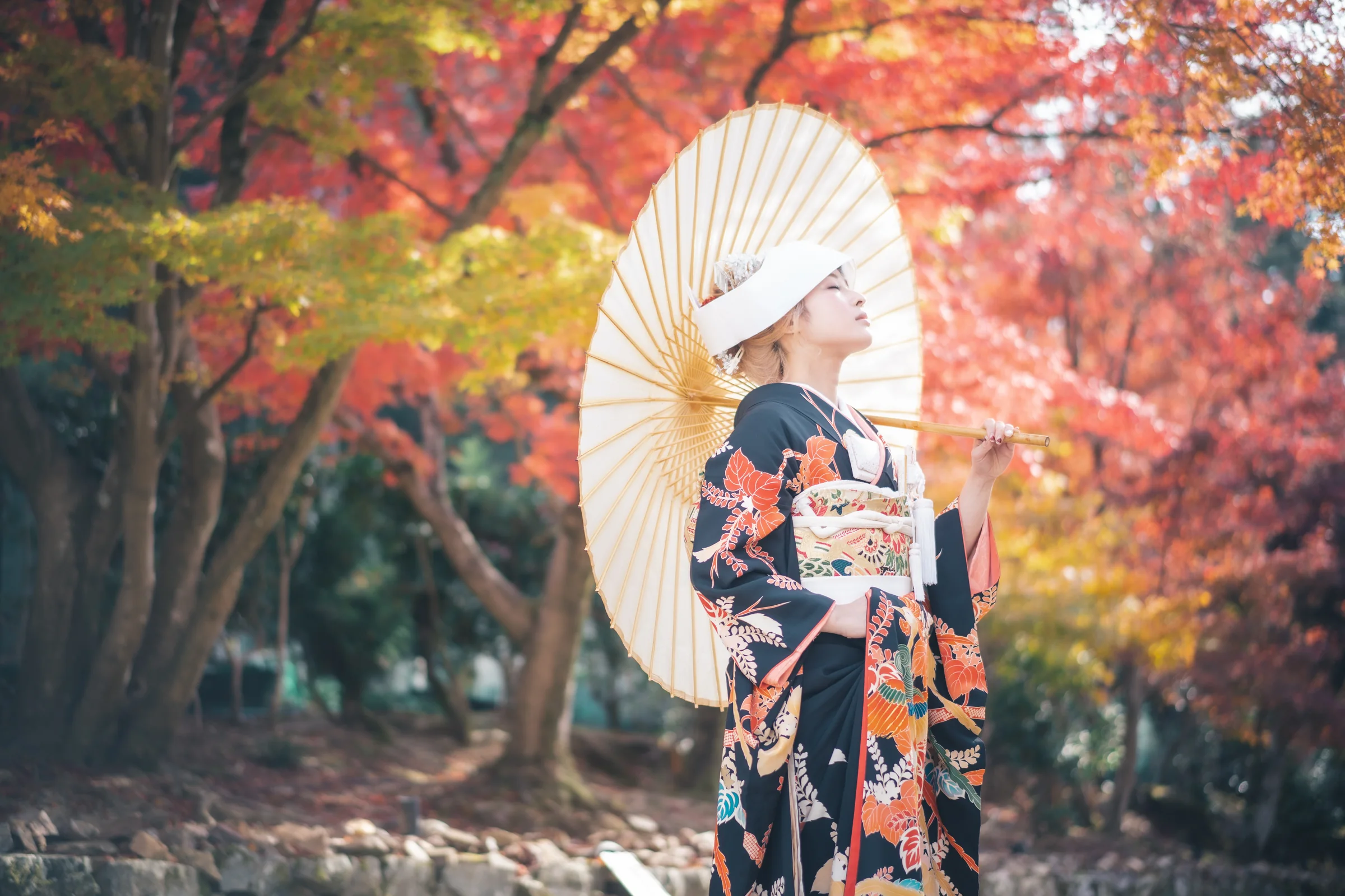 色づく紅葉の中で和傘を持つ引振袖姿